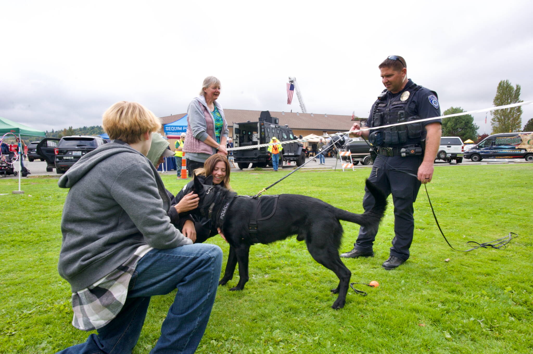 K-9 Officer Ken McKnight with the Port Angeles Police Department and Freddy the German Shepherd greet Sequim residents Riley Galvin, Joseph Vuckel, Haley Holden, and Darlene Cook at the Clallam County Public Safety Fair. McKnight said he and Freddy completed a 400-hour special training program for certification as a K-9 officer.