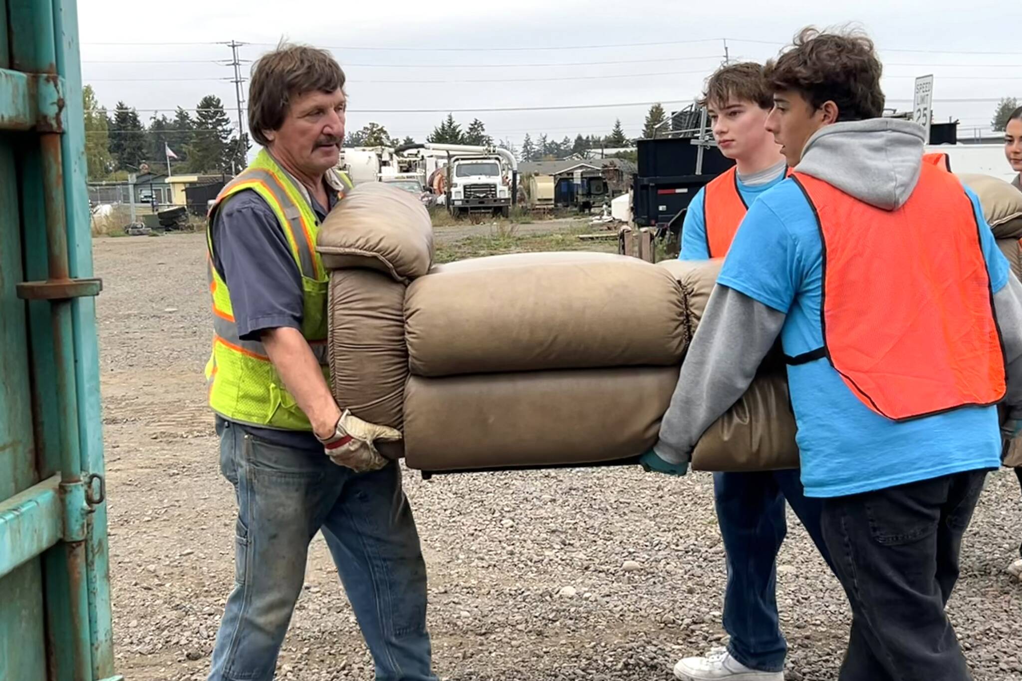 Sequim Gazette photos by Matthew Nash
Gary Myer, a Sequim maintenance worker, works with Sequim High School Interact Club members John Pehrson, president, and Nico Musso, photographer, to move a couch during Rally in the Alley on Oct. 18. Local residents dropped off unwanted items for free at the City Shop and Carrie Blake Community Park.