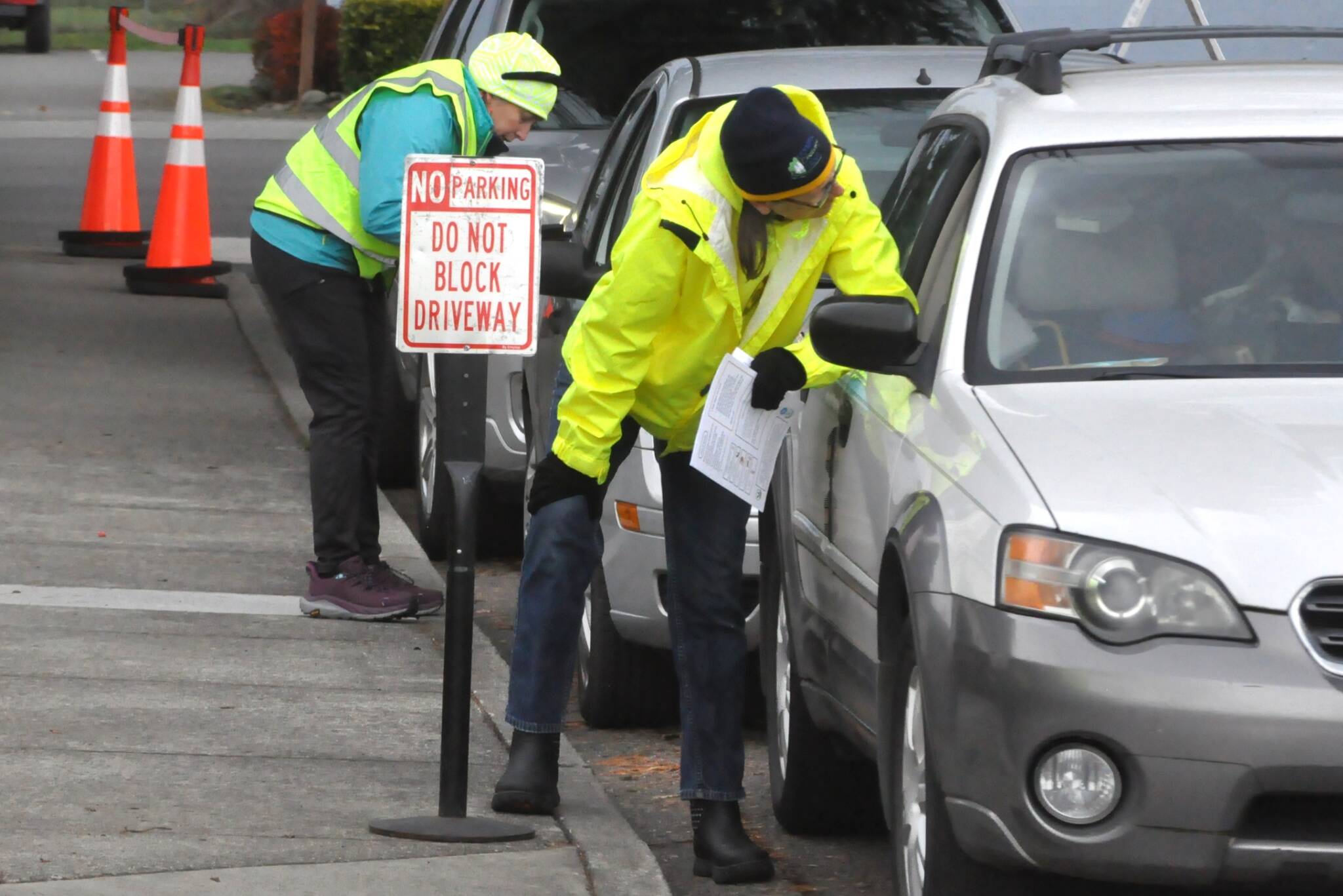 Sequim Gazette photo by Matthew Nash/
Jen Colmore, community engagement coordinator for the Sequim Food Bank, on right, and Maci MacPherson, resource navigator for the YMCA/Olympic Connect, left, speak with visitors of the food bank on Oct. 31 to see if there are additional resources they can receive. Lines have grown larger in recent weeks at the food bank, staff report.