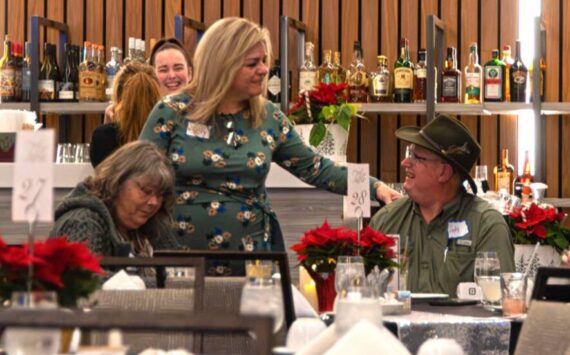 Sequim Gazette photo by Monica Berkseth
Sequim Valley Lions Club marketing chair Cely Alhaddad greets attendees at the Saturday, Dec. 6 event at 7 Cedars commemorating the nonprofit’s 70th anniversary.
