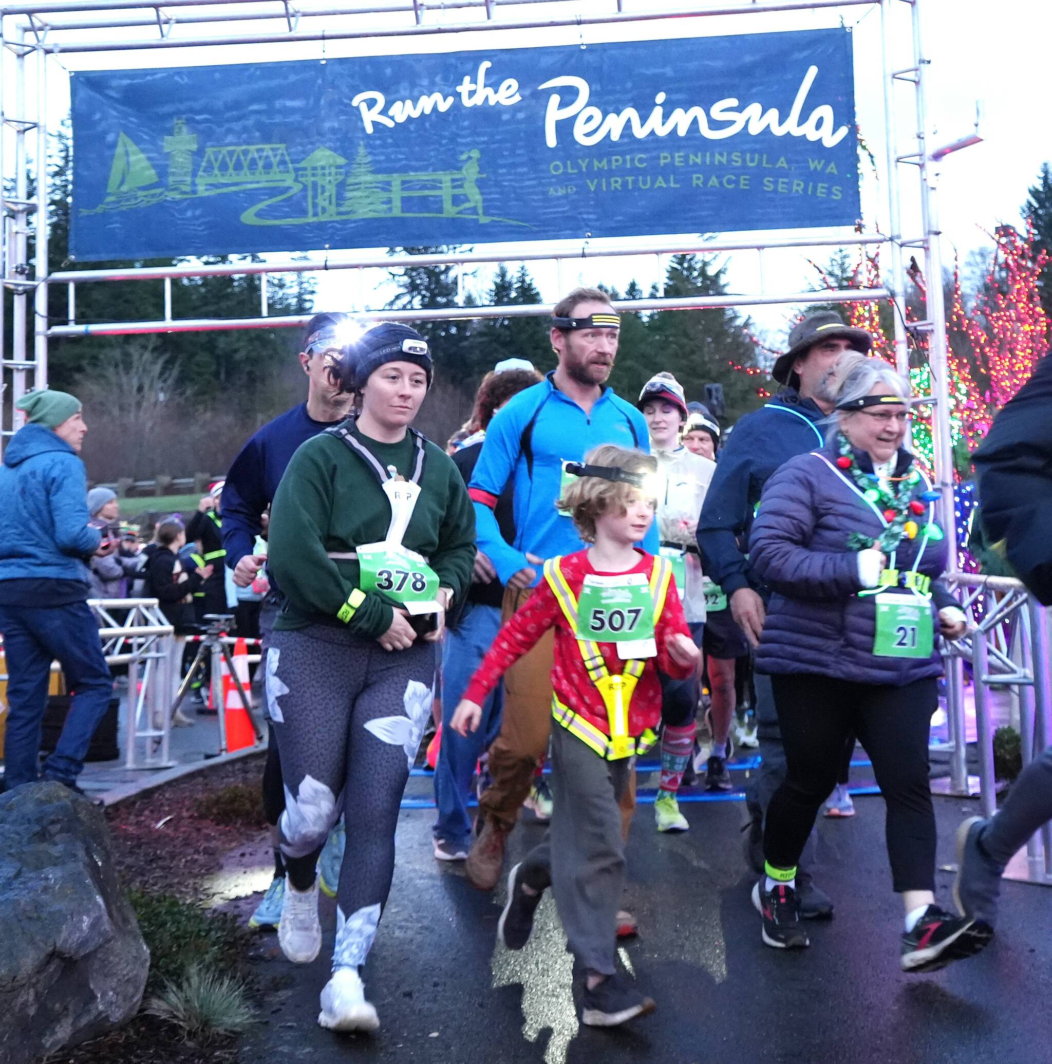 Photo courtesy Michael Dashiell, Jamestown SKlallam Tribe
Aaliyah Clark of Poulsbo (378) and Monica Castleberry of Lacey (21) lead a young runner at the start of the Jamestown SKlallam Glow Run in Blyn on Dec. 6. The race had a record-breaking 900 participants this year.
