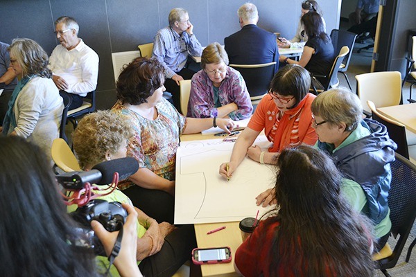 Community members and leaders brainstorm T-shirt ideas promoting Sequim at a community engagement seminar led by author Peter Kageyama.