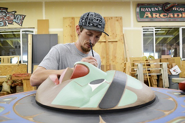Dusty Humphries puts finishing touches on the totem pole set for the Sequim Civic Center’s community plaza. Dale Faulstich designed it and he