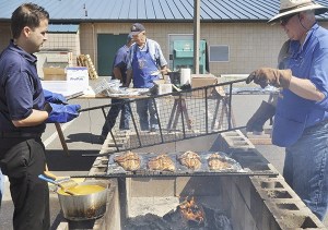 Rotarians tend to a fresh batch of salmon at Sequim Noon Rotary’s 47th annual Salmon Bake & BBQ on Aug. 9 at the Sequim Boys & Girls Club.