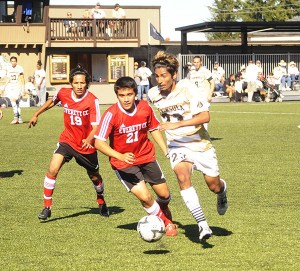 Peninsula's Keo Ponce drives past Everett's Jonathan Flores (21) and Gabriel Macias-Neri (19) in the first half of the Pirates' 7-3 win Saturday in Port Angeles.
