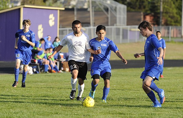 Sequim's Brandon Payne (22) drives through the Olympic defense to put a shot on goal in the Wolves' 8-0 win Monday night against Olympic.