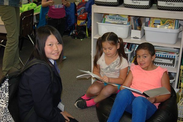 Second-graders Selina Meyer and Sofia Chavez read to visiting student Amu Nagata during the tour of Teresa Thorson’s second-grade classroom at Helen Haller Elementary School.