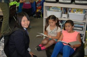 Second-graders Selina Meyer and Sofia Chavez read to visiting student Amu Nagata during the tour of Teresa Thorson’s second-grade classroom at Helen Haller Elementary School.