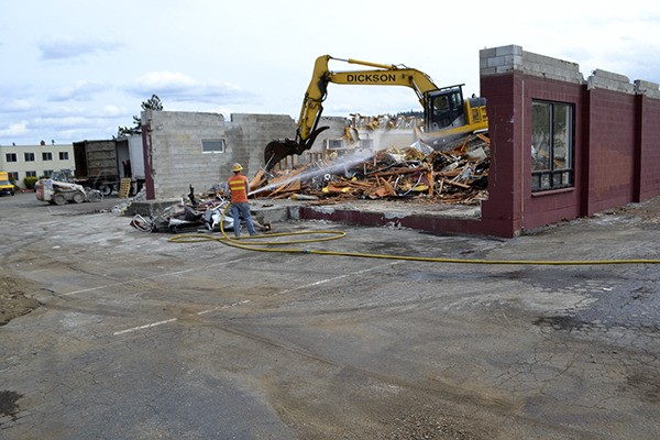 Lydig Construction crew members work to take out the center of the City of Sequim’s former city hall on Tuesday afternoon. Demolition began on April 14 and crews anticipate demolition of the former Serenity House Thrift Shop and apartments next. The project clears space for the city’s new Civic Center and Police Station.