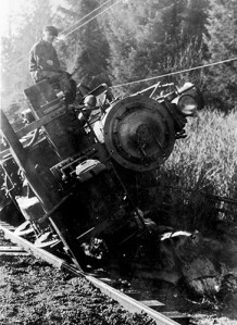 Men sit atop on pilot beam of an engine after a train wreck and derailment near Clallam Bay.