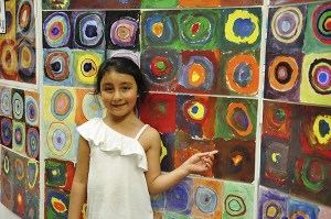 Kindergartner Paloma Franco from Stephanie Grotzke-Nash’s class points out her work at the Aspiring Artists & Promising Painters Art Show.