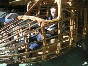 Frank Wajda tries out the cockpit of his bush plane-in-process. He has been steam-bending Sitka spruce for years to create the framework. The plane’s wingspan is 36 feet.