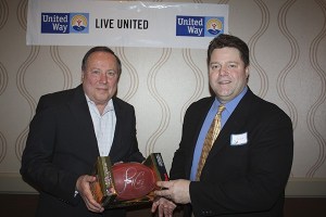 United Way of Clallam County board president Don Bradley (left) presents an autographed football to 2013 Campaign chairman Buck Gieseke.