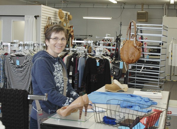 Sequim resident and past volunteer at Second Chance Rebecca Wallace purchases a blue athletic jacket she found during her first visit back to store’s location since the consignment store reopened under different ownership.