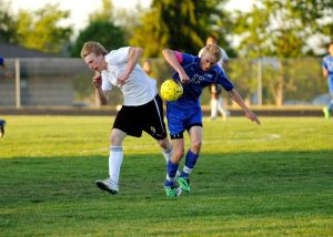 Kyle Harrison collides with Olympic's Nick Decker on May 7 in Sequim's 4-1 over the Trojans.