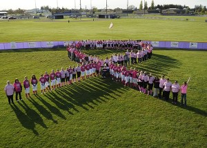Sequim High School and Port Angeles High School fastpitch players join community members at the SHS softball field on April 28.