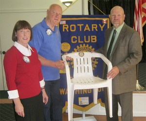 Noon Club President Sara Maloney stands by as the club’s Sergeant-at-Arms Joe Watkins presents a token chair to Sequim School District Superintendent Kelly Shea at the club meeting on May 28.