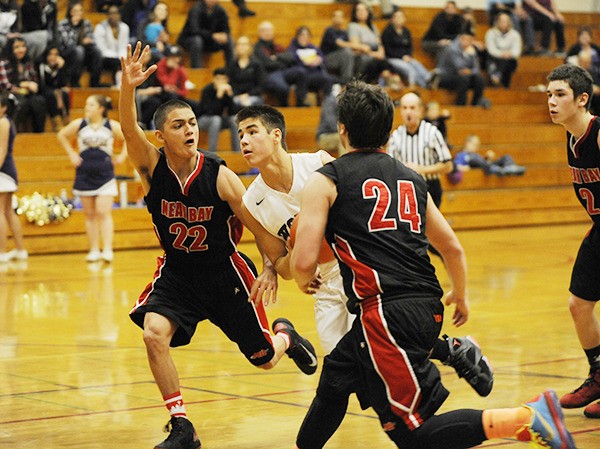 Sequim guard Payton Glasser drives past Kendrick Doherty (22) and Ryan Moss (24) of Neah Bay in a non-league matchup on Dec. 10. Glasser scored 13 points in the Wolves’ 65-60 win.