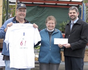 The Rev. Diane Moore of St. Luke’s Episcopal Church presents director Mark Ozias with over $1