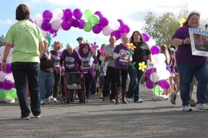 Carrying “Promise Garden” flowers of four different colors to represent the varying connections to Alzheimer’s disease