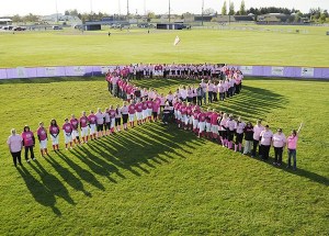 Community members and softball players gather for a group photo to raise awareness about cancer in Sequim in 2014.