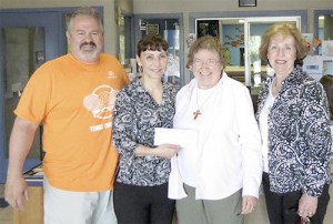 Unit Director Dave Miller and Executive Director Mary Budke receive the check from the Rev. Diane Moore and Kara Selby.