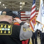 Mike Money of Port Angeles, a U.S. Navy veteran who served in Vietnam, salutes as a color guard passes during last Friday&rsquo;s Veterans Day ceremony in the hangar of U.S. Coast Guard Air Station/Sector Field Office Port Port Angeles. (Keith Thorpe/Peninsula Daily News)
