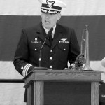 Keith Thorpe/Peninsula Daily News A family heirloom bugle graces the dias as U.S. Coast Guard Cmdr. Mark Hiigel, commanding officer of Air Station/Sector Field Office Port Angeles, speaks during Friday&rsquo;s Veteran&rsquo;s Day ceremony.