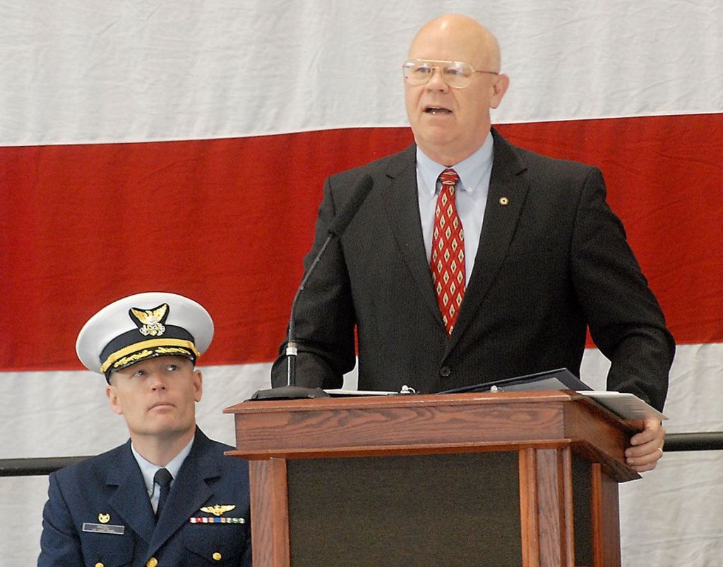 Retired U.S. Coast Guard Rear Adm. Richard Gromlich, right, delivers the keynote address during last Friday&rsquo;s Veterans Day ceremony in the hanger of U.S. Coast Guard Air Station/Sector Field Office Port Port Angeles. Looking on at left is Cmdr. Mark Hiigel, commanding officer of the station. (Keith Thorpe/Peninsula Daily News)