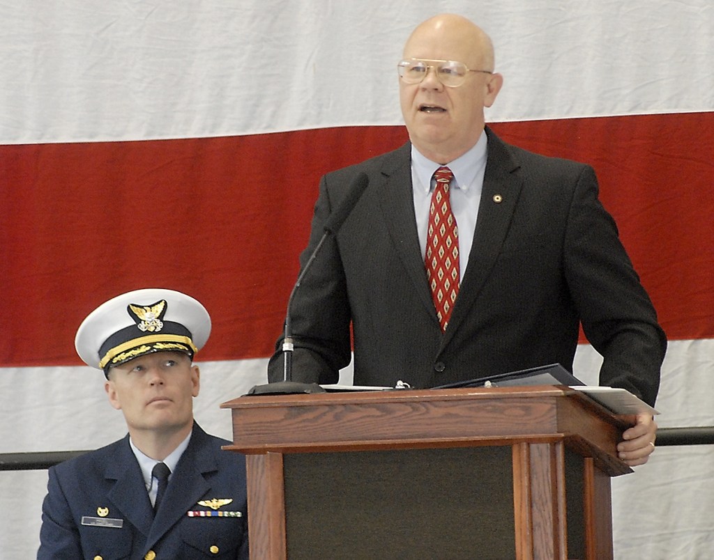 Keith Thorpe/Peninsula Daily News Retired U.S. Coast Guard Rear Admiral Richard Gromlich, right, delivers the keynote address during Friday&rsquo;s Veteran&rsquo;s Day ceremony in the hanger of U.S. Coast Guard Air Station/Sector Field Office Port Port Angeles. Looking on at left is Cmdr Mark Hiigel, commanding officer of the station.