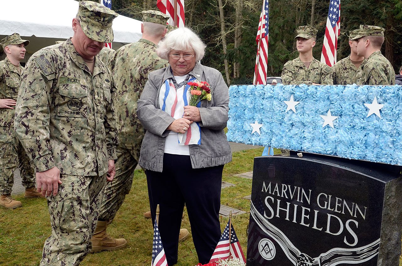 Joan Shields, the widow of Medal of Honor recipient Marvin Shields, stands beside his grave with a group of local servicemen who came out on Veterans Day to honor her late husband&rsquo;s service Friday. (Cydney McFarland/Peninsula Daily News)