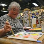 Sequim artist Linda Stadtmiller works on her latest piece &ldquo;The Three Muses&rdquo; at her studio space in the Landing Artist Studio. Following a stroke, she&rsquo;s switched hands to paint. Sequim Gazette photo by Matthew Nash