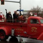Above, Santa Claus and Sequim Irrigation Festival royalty ride on an antique fire truck from Clallam County Fire District 3. At right, members of the Sequim City Band warm up the crowd with lively music on Nov. 26 in Downtown Sequim. Submitted photos