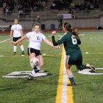 Sequim midfielder Adare McMinn advances the ball by Port Angeles&rsquo; Emily Boyd on Nov. 3 in the West Central Districts game in Bremerton. Sequim Gazette photo by Matthew Nash
