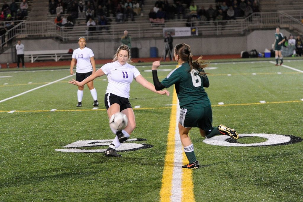 Sequim midfielder Adare McMinn advances the ball by Port Angeles&rsquo; Emily Boyd on Nov. 3 in the West Central Districts game in Bremerton. Sequim Gazette photo by Matthew Nash