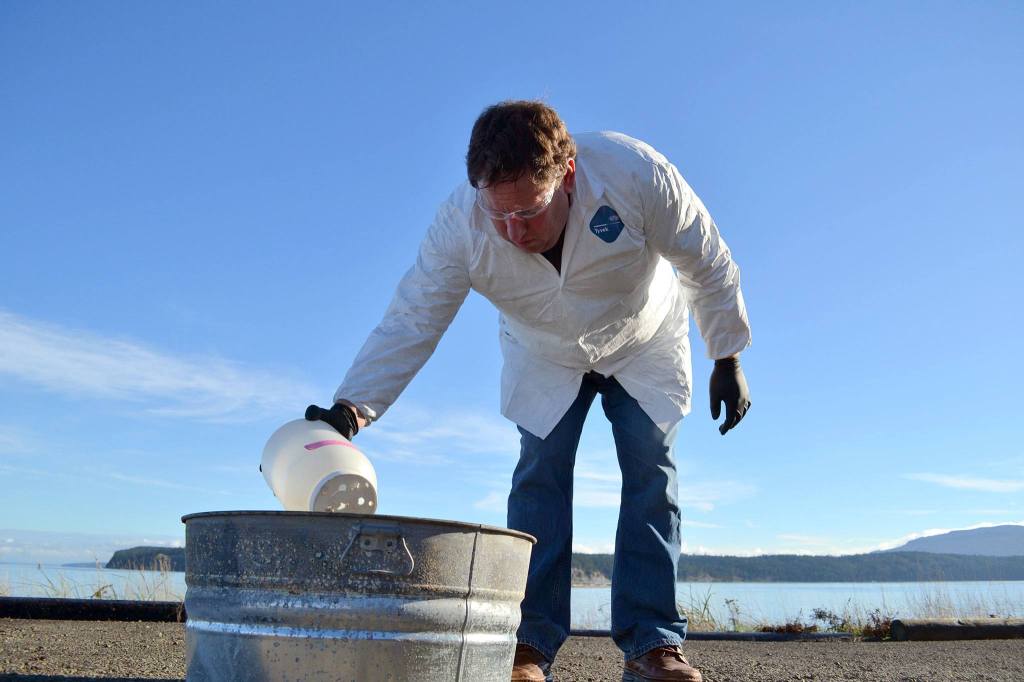 Scientist Robert Jeters, project manager for the Pacific Northwest National Laboratory&rsquo;s aggregator product, applies the product to an oil slick to gauge how much of it is needed to effectively burn the oil out of the water. Sequim Gazette photo by Matthew Nash