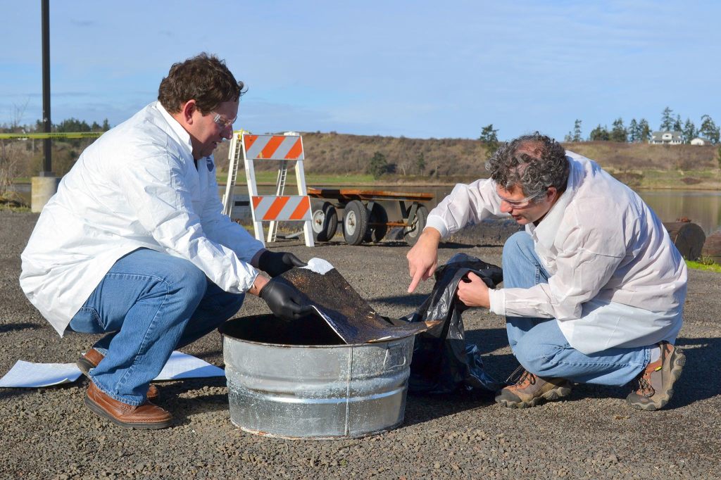 Scientists Robert Jeters and George Bonheyo with the Pacific Northwest National Laboratory in Sequim investigate an absorbent pad to see how much oil is leftover after it was burned using an aggregator product to promote burning. Sequim Gazette photo by Matthew Nash