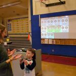 Physical Education teacher Holly Thornton at Helen Haller Elementary talks with Corbyn Lovell about the Heart Tech Plus monitors. She said the program is a good way to measure student effort in class and talk about their hearts. Sequim Gazette photo by Matthew Nash