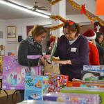 Farah Durham of Sequim looks for toys for her 4-year-old daughter with help from volunteer Gisele Gala at Toys for Sequim Kids on Dec. 14 in the Sequim Prairie Grange. &ldquo;It&rsquo;s a blessing to help others because God has blessed us so abundantly,&rdquo; Gala said. Sequim Gazette photo by Matthew Nash
