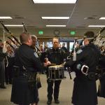 Retiring Sequim Police Chief Bill Dickinson, on left, listens in as the Seattle Police Pipes & Drums group plays for his ceremony on Dec. 1 in the Sequim Transit Center. His son, Joe Dickinson with the Lynnwood Police Department, played drums. Sequim Gazette photo by Matthew Nash
