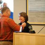 Pat Crain pins the Sequim police chief badge on his wife Sheri Crain on Friday, Dec. 16, after she was sworn into the position. Sequim Gazette photo by Matthew Nash