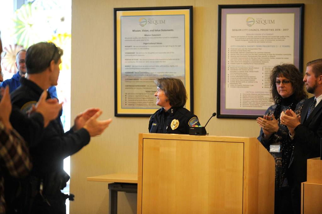 A full crowd inside the Sequim City Council&rsquo;s chambers gives new police chief Sheri Crain a standing ovation after she was sworn into office on Friday, Dec. 16. Sequim Gazette photo by Matthew Nash