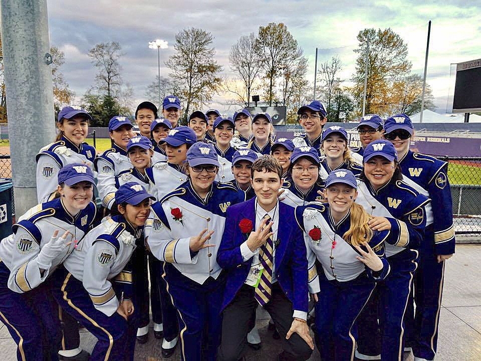 Sequim High grads Sarah Doty (front row, third from left) and Mikaele Baker (third row, far right) join their fellow UW Marching Band seniors and flash some &ldquo;Ws&rdquo; for the University of Washington at their last home football game. Submitted photo