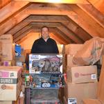 Jon Gray of Sequim stands in his attic with boxes of &ldquo;Star Wars&rdquo; toys he&rsquo;s collected since the mid-1990s. He buys two of each action figure with the goal to keep one in box and a second to display. Sequim Gazette photo by Matthew Nash