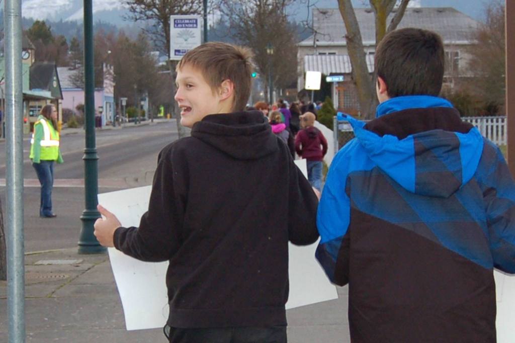 Seventh-graders Blake McGowan, left, held a sign that read &ldquo;Freedom To All! SMS&rdquo; while Perry Sharpes, right, shows a poster that read &ldquo;Honor King &mdash; End Racism&rdquo; during the Martin Luther King Jr. Day walk on the morning of Friday, Jan. 13. Sequim Gazette photo by Erin Hawkins