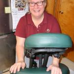 Massage therapist Cheryl Powell strikes a pose with her portable massage chair. Sequim Gazette photo by Patricia Morrison Coate