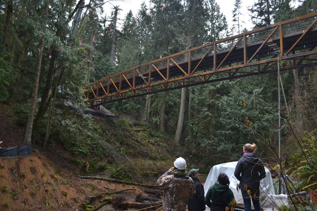 Park officials watch crewmen place a new bridge in Sequim Bay State Park on Jan. 19. Sequim Gazette photo by Matthew Nash