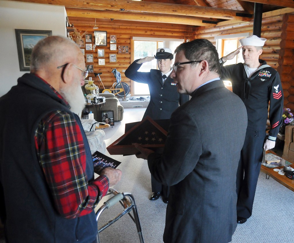 As Pearl Harbor veteran Bob Rains talks with Tim Katona, president of the Navy League Bremerton-Olympic Peninsula Council, YN2 (yeoman) Kate Pope and YN1 (yeoman) Hogan Sternbeck stand in salute. Rains accepted a flag from Katona that was flown over the USS Arizona memorial in Hawaii. Sequim Gazette photos by Michael Dashiell
