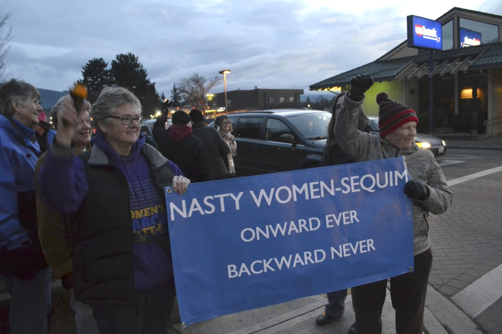 Kathi White and Donna Maclean hold one of the few signs up at the women&rsquo;s rights rally in downtown Sequim on Jan. 21. Maclean said their sign is a response to President Donald Trump calling his opponent Hillary Clinton a &ldquo;nasty woman&rdquo; at a debate.