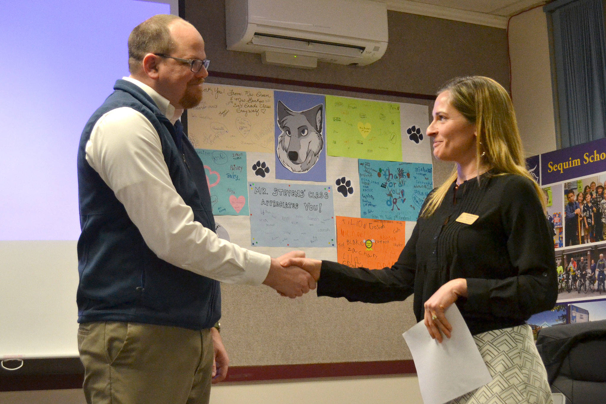 Brian Kuh shakes hands with Robin Henrikson, board president for the Sequim School Board, on Monday, March 20, after he was sworn in as a new board director. He replaces Bev Horan who stepped down on March 7. Sequim Gazette photo by Matthew Nash